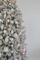 new year and Christmas tree with white and pink toys under the snow