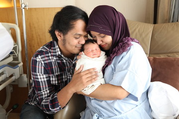 Asian Muslim mother and father hugging newborn or baby with love. family and love concept.