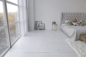 elegant bed with green and gild pillows at bedroom of the luxury apartment with white walls