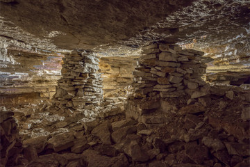 view of limestone mine with two stone columns illuminated by counter light.