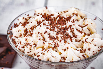 Homemade chocolate mousse in portion glass on wooden background. Close up