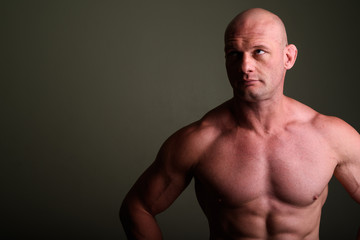 Fototapeta premium Bald muscular man shirtless against colored background