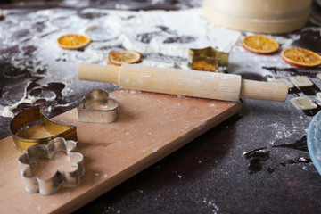 Winter, New Year's Flat lay: flour cookies, dried mandarin, rolling pin, cookie cutter, wooden board with russian letters 