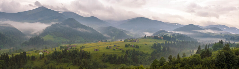 Fototapeta na wymiar Fantastically beautiful morning in the Carpathians in the summer. amazing view of the mountain village Dzembronya foggy morning in the mountains in summer.