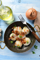 Meat stuffed potato dumplings with fried onion  and greaves on top