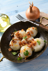 Meat stuffed potato dumplings with fried onion  and greaves on top