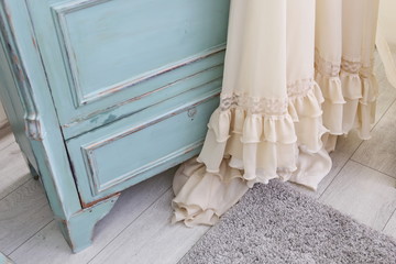  fine beige fabric with ruffles at the turquoise wooden chest