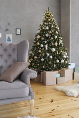 elegant Christmas tree with gifts in the living room with gray sofa textured gray walls in luxury apartments