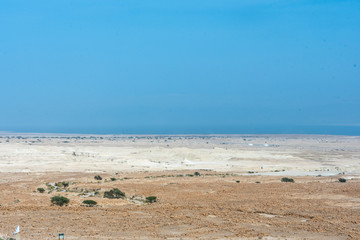 Desert of Judea and in the background on the horizon the shores of the Dead Sea. Israel