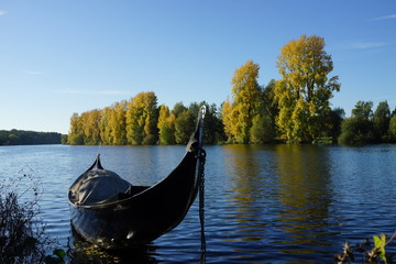 Kanu auf einem Fluss, am gegenüberliegenden Ufer herbstlich gefärbte Bäume