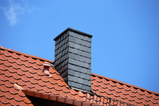New tiled roof with chimney with slate cladding