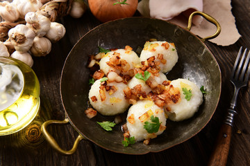Meat stuffed potato dumplings with fried onion  and greaves on top