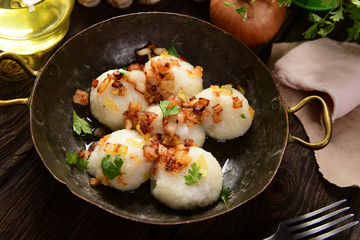 Meat stuffed potato dumplings with fried onion  and greaves on top