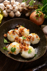 Meat stuffed potato dumplings with fried onion  and greaves on top
