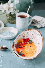 Crème brûlée with chocolate dessert with flowers. Foodstyling with tea on wooden background.