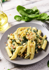 Penne pasta with spinach, gorgonzola cheese and walnuts