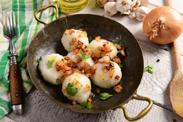Meat stuffed potato dumplings with fried onion  and greaves on top