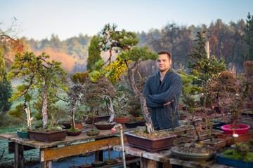 Young man bonsai artist in his bonsai farm