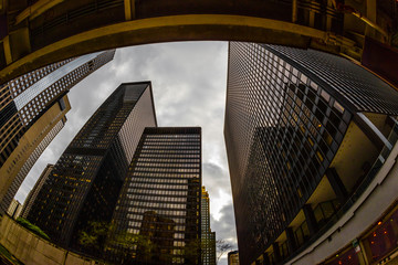 Wide-angle view looking up through tall buildings and skyscrapers in downtown Chicago Illinois