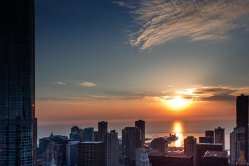 Aerial view looking out over downtown Chicago Illinois and Lake Michigan as the sun rises over the horizon