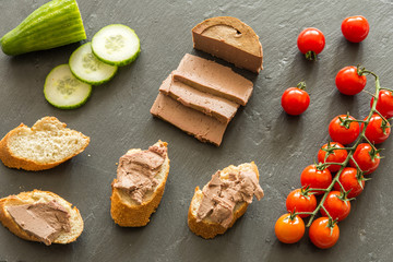 breakfast with liver pate cherry tomatoes cucumber on a slate plate