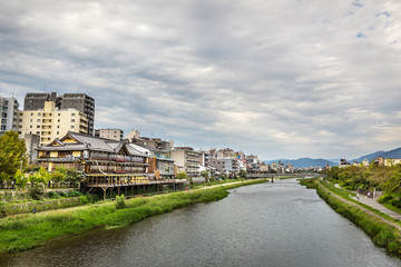 Fototapeta premium A river crossing the city of Kyoto in a cloudy day in Japan