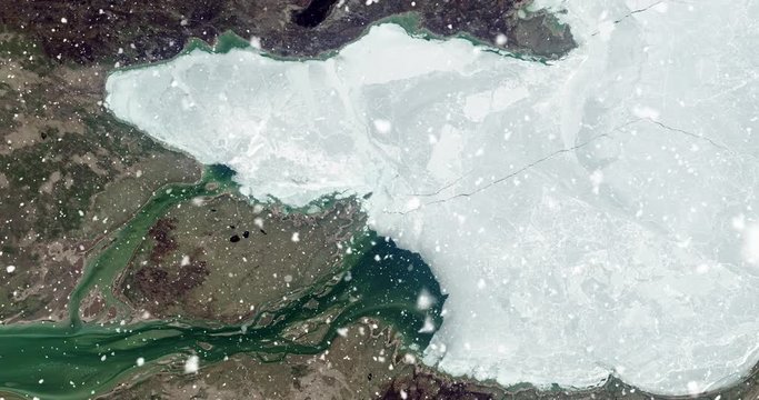 Vertical aerial ascent through heavy falling snow, over Great Slave Lake, Canada. Elements of this image furnished by NASA. 