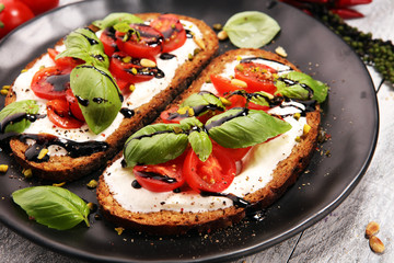 Bread with cream cheese and tomato for lunch table. Sharing antipasti on party or summer picnic...