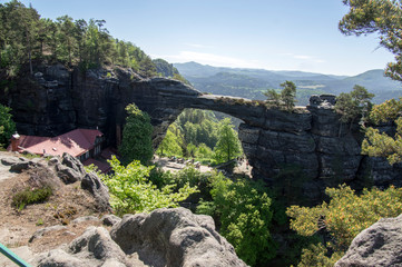 Pravcicka brana is a narrow rock formation located in Bohemian Switzerland, late spring scenery with greenery, blue sky