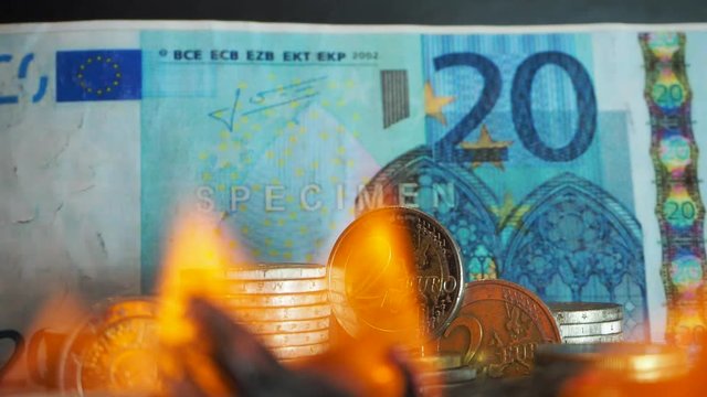 twenty euros - 20 and euro-coins burn in a fire on a black background. Close up of european currency is on fire. Concept of stock market crash and currency depreciation. 4k. Conceptual finance image D