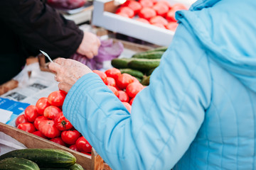 woman buys products in market. pays for goods money