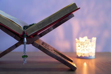 Quran and rosary beads on the white background with light lantern or candle for Islamic concept. Holy book Koran for Muslims holiday, Ramadan,blessed Friday message and three months