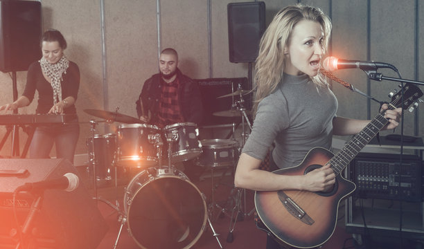 excited girl rock singer with guitar during rehearsal