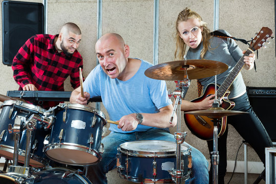 Rehearsal of music group with male drummer