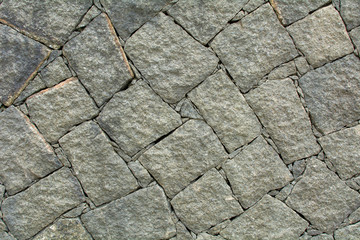 Texture of broken gray and old stones with dirt and vegetation