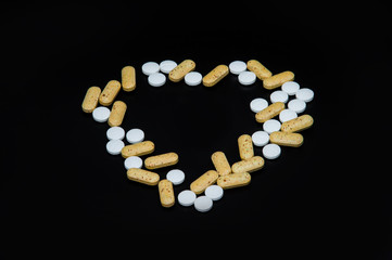 heart shaped pills on a black background