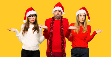 Fototapeta premium A group of people Girl with celebrating the christmas holidays having doubts and with confuse face expression on yellow background