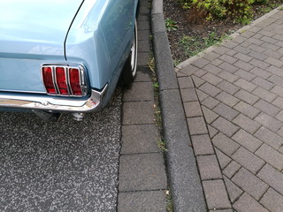 Amerikanischer Sportwagen Klassiker der Sechzigerjahre in Hellblau Metallic am Bordsteinrand im...