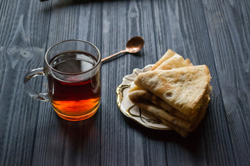 A cup of tea and cakes on a rustic table. Cozy winter time.