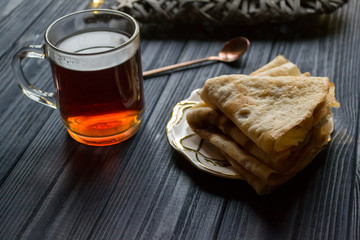 A cup of tea and cakes on a rustic table. Cozy winter time.