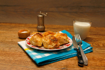 Traditional Bosnian pastry- manti borek with cheese on wooden table with yogurt. rustic background with low light and old bowls.