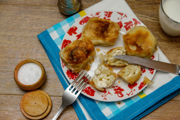 Traditional Bosnian pastry- manti borek with cheese on wooden table with yogurt. rustic background with low light and old bowls.
