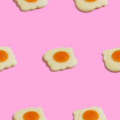 Creative seamless pattern with scrambled eggs on pink background. Food abstract background