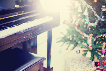 Piano and shine to Christmas tree for christmas holiday background.