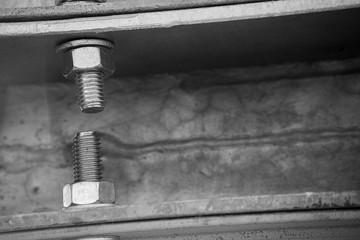 Monochrome bolts with nuts in a metal construction