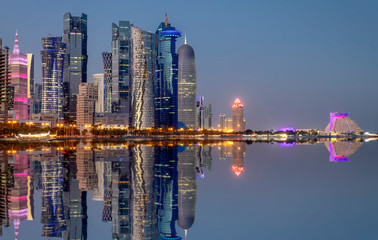 Die Skyline der West Bay von Doha, Qatar, am Abend mit Reflektionen in der Bucht