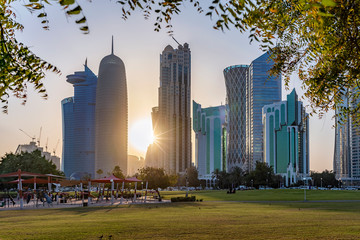 Die moderne Skyline des City Centers von Doha, Katar, bei Sonnenuntergang, gesehen von einem Park