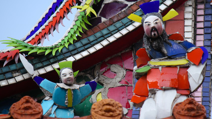 Obraz premium Stone carving and glass mosaic arts and decoration showing buddhist temple symbolic and religous elements and animals in downtown Taichung, Taiwan