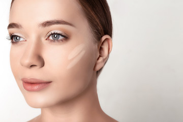 Naklejka premium Portret piękna młoda kobieta z makeup rozmazuje na twarzy przeciw białemu tłu