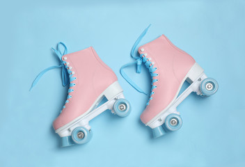 Pair of stylish quad roller skates on color background, top view